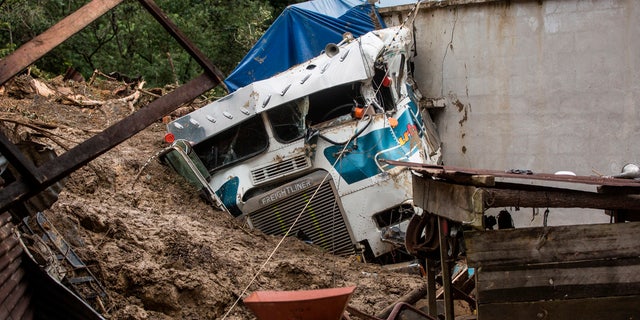 A semi is partially buried in a massive, rain-fueled landslide in the village of Queja, in Guatemala, Saturday, Nov. 7, 2020, in the aftermath of Tropical Storm Eta.