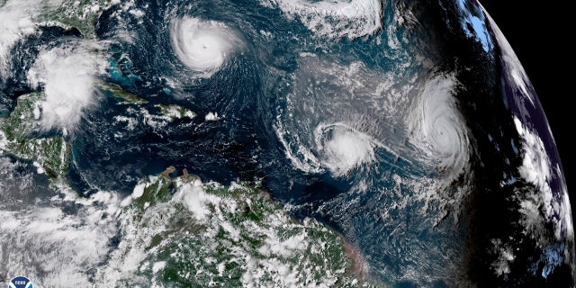 This enhanced satellite image made available by NOAA shows Tropical Storm Florence, upper left, in the Atlantic Ocean on Tuesday, 九月. 11, 2018 在 3:30 下午. EDT. At center is Tropical Storm Isaac and at right is Hurricane Helene.