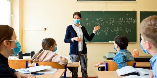 Teacher wearing N95 mask teaches math (iStock)