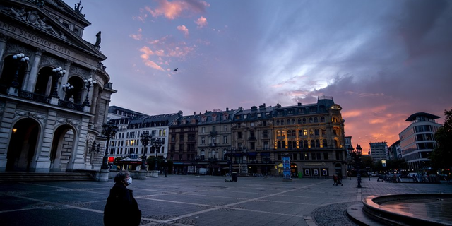 <br>
A woman wearing a face mask walks past the Old Opera, left, in Frankfurt, Germany, before sunrise on Monday, Nov. 9, 2020. (AP Photo/Michael Probst)