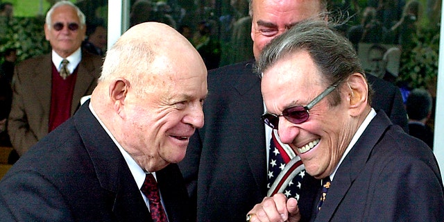 FILE - In this April 1, 2002, file photo, comedians Don Rickles, left, and Norm Crosby arrive for a ceremony honoring comedian Milton Berle at Hillside Memorial Park and Mortuary in Los Angeles. Crosby, the deadpan mangler of the English language who thrived in the 1960s, ’70s and ’80s as a television, nightclub and casino comedian, has died. He was 93. Crosby’s daughter-in-law, Maggie Crosby, told the New York Times that the comic died Saturday, Nov. 7, 2020 of heart failure in Los Angeles. (AP Photo/Nick Ut, File)