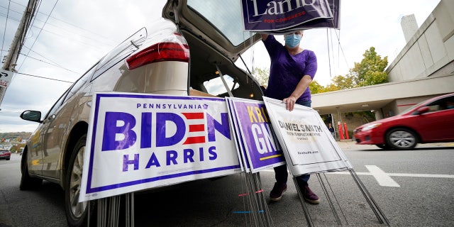 Anne Schirra Baker distributes campaign signs from her car outside the Butler County Democratic Committee headquarters in Butler, Pa., on Thursday, Oct. 15, 2020.