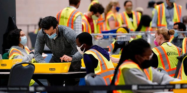 Philadelphia election workers process mail-in and absentee ballots for the general election, at the Pennsylvania Convention Center, Tuesday, Nov. 3, 2020, in Philadelphia. (AP Photo/Matt Slocum)