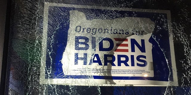 A group vandalized the Multnomah County Democrats office in Portland on Sunday. An Oregonians for Biden-Harris campaign poster is seen behind the shattered glass window. (Portland Police Bureau)