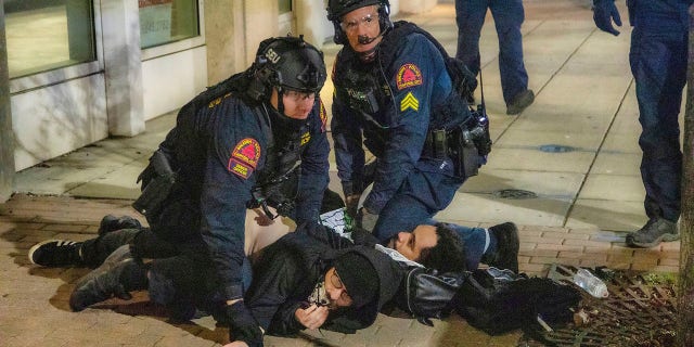 Police arrest a pair of protesters as demonstrators marched around downtown Raleigh after the polls closed Tuesday night. (Travis Long/The News & Observer via AP)