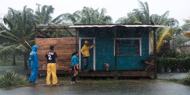 Residents stand outside a home surrounded by floodwaters brought on by Hurricane Eta in Wawa, Nicaragua, Tuesday, Nov. 3, 2020. AP Photo/Carlos Herrera