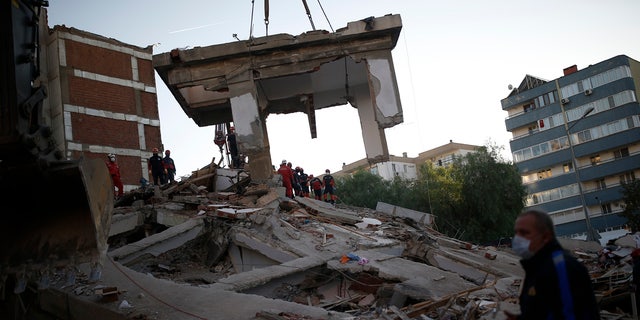Members of rescue services search for survivors in the debris of a collapsed building in Izmir, Turkey, Saturday, Oct. 31, 2020.