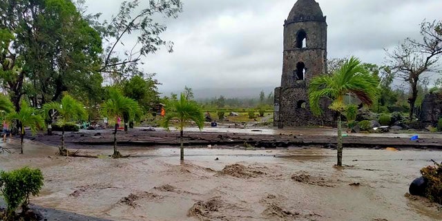 Floodwaters pass by Cagsawa ruins, a famous tourist spot in Daraga, Albay province, central Philippines as Typhoon Goni hit the area Sunday, Nov. 1, 2020.