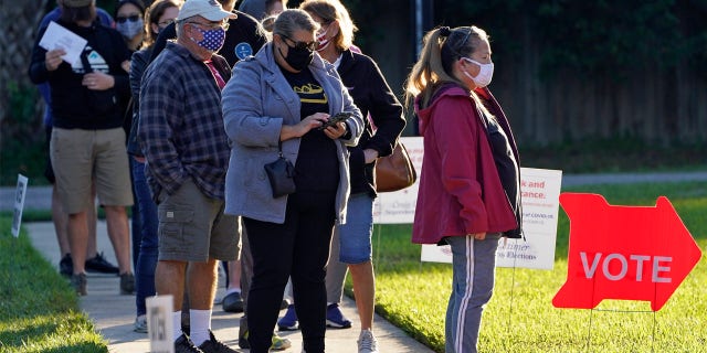 People wear protective face masks as they wait in line to vote at the Bell Shoals Baptist Church on election day Tuesday, Nov. 3, 2020, in Brandon, Fla. (AP Photo/Chris O'Meara)
