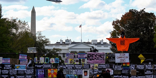 Helicopter passes over the White House, seen behind a fence and protest posters, the day before the U.S. presidential election in Washington, D.C., U.S., November 2, 2020. (Reuters/Erin Scott)