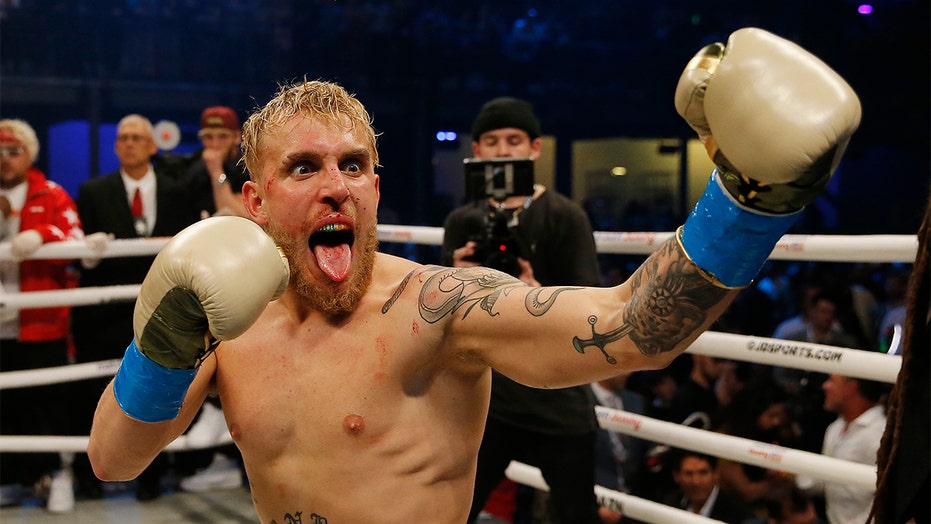 Jake Paul flexing in boxing gloves