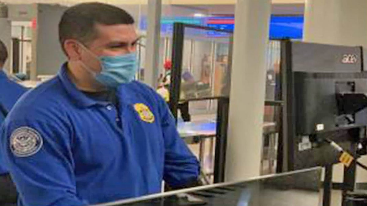 A Transportation Security Administration officer stands at an airport checkpoint. On Thursday, the TSA asked passengers to act calm and respectful at checkpoints amid a series of incidents involving unruly passengers. 