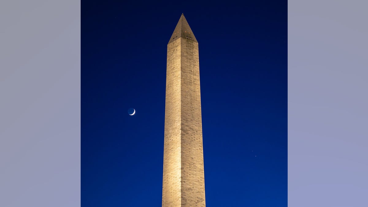 The Moon, left, Saturn, upper right, and Jupiter, lower right, are seen after sunset with the Washington Monument, Thurs. Dec. 17, 2020, in Washington. The two planets are drawing closer to each other in the sky as they head towards a "great conjunction" on December 21, where the two giant planets will appear a tenth of a degree apart. Photo Credit: (NASA/Bill Ingalls)
