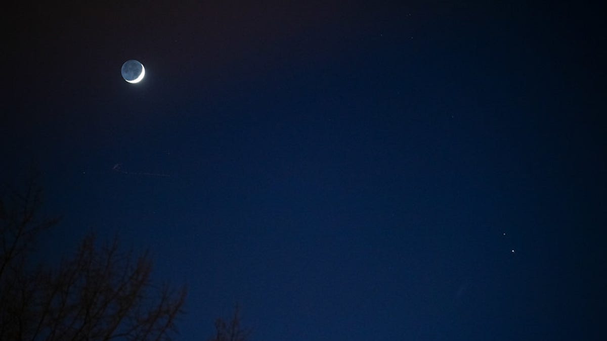 The Moon, left, Saturn, upper right, and Jupiter, lower right, are seen after sunset from Washington, DC, Thurs. Dec. 17, 2020. The two planets are drawing closer to each other in the sky as they head towards a "great conjunction" on December 21, where the two giant planets will appear a tenth of a degree apart. Photo Credit: (NASA/Aubrey Gemignani)