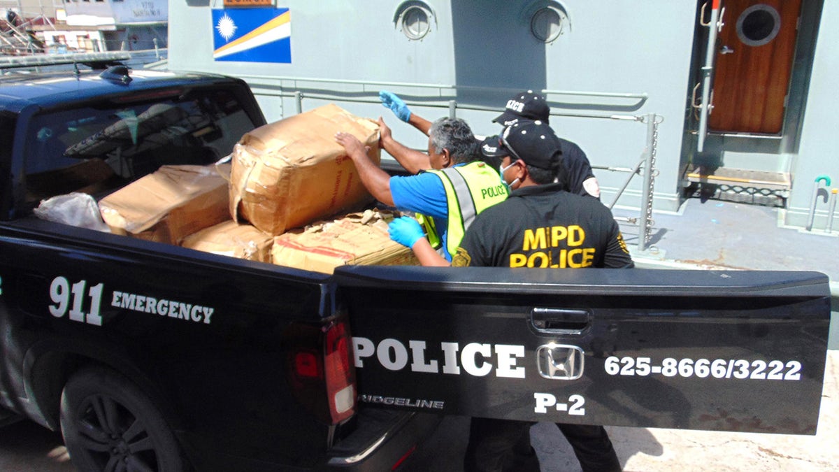 A photo on December 15, 2020, shows Marshall Islands police loading a box filled with one-kilo "bricks" of cocaine into a police pickup truck from a patrol vessel that transported the cocaine from a remote outer atoll to Majuro for confiscation and destruction. - An 18-foot fiberglass boat was found washed up on Ailuk Atoll, a remote atoll with about 400 people, in the Marshall Islands last week with 649 kilos (1,340 pounds) of cocaine sealed in its hold under the deck. (Photo by Giff JOHNSON / AFP) (Photo by GIFF JOHNSON/AFP via Getty Images)