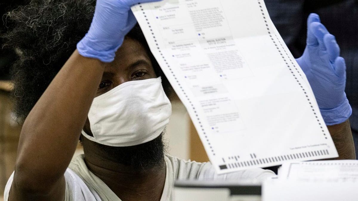 Workers scan ballots as the Fulton County presidential recount gets under way Wednesday morning, Nov. 25, 2020 at the Georgia World Congress Center in Atlanta. (AP Photo/Ben Gray)