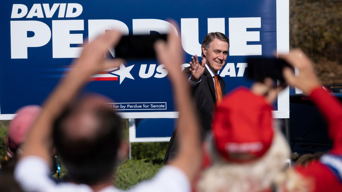 FILE - In this Nov. 20, 2020, file photo Sen. David Perdue, R-Ga., takes the stage before Vice President Mike Pence during a Defend the Majority Rally in Canton, Ga. (AP Photo/Ben Gray, File)