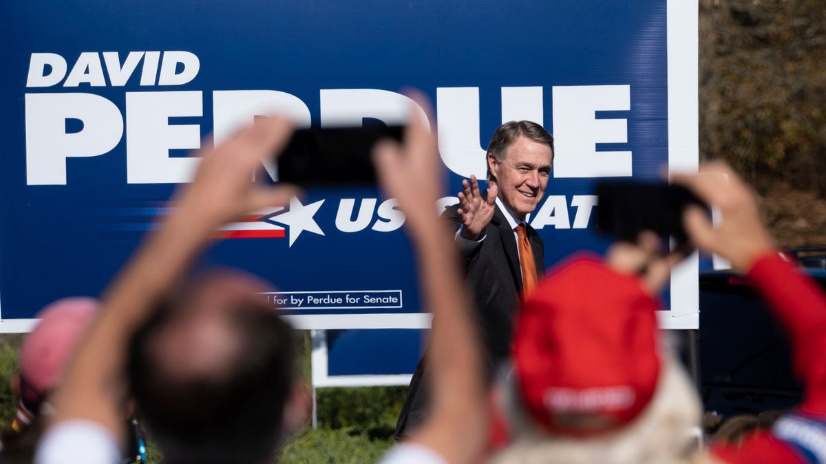 In this Nov. 20, 2020, file photo Sen. David Perdue, R-Ga., takes the stage before Vice President Mike Pence during a Defend the Majority Rally in Canton, Ga. (AP Photo/Ben Gray)