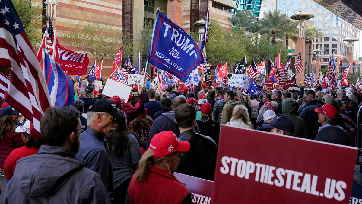 Supporters of President Donald Trump protest in front of a local hotel where Arizona Republicans have scheduled a meeting as a "fact-finding hearing" to discuss the election, featuring members of Trump's legal team and Arizona legislators, Monday, Nov. 30, 2020, in Phoenix. (AP Photo/Ross D. Franklin)