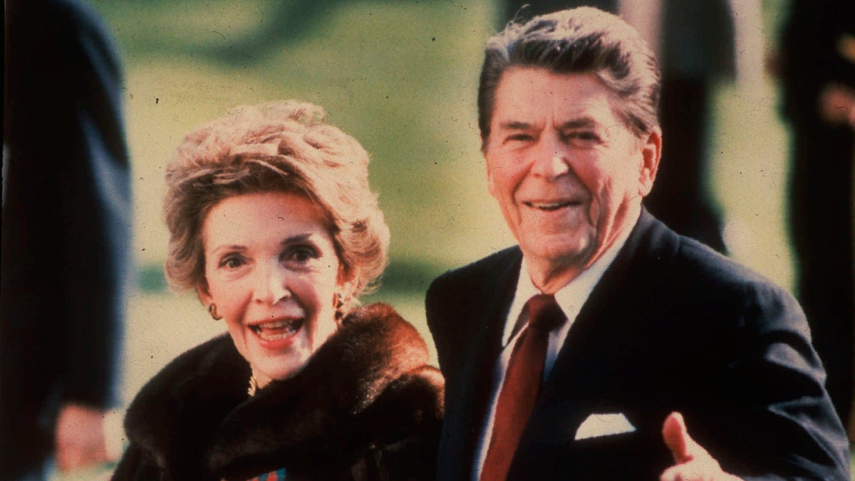 First lady Nancy Reagan and President Reagan walk on the White House south lawn in December 1986. (AP Photo/Dennis Cook, File)