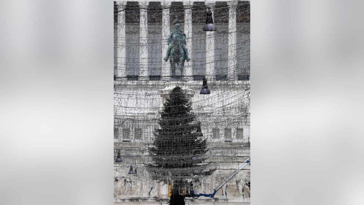 Turned off Christmas lights are backdropped by a 23mt (75 feet) tall fir tree placed in front of Rome's Unknown Soldier monument, Tuesday, Dec. 1, 2020. Still, the large number of daily new COVID-19 cases is worrying, Italian health experts said, especially with the approach of year-end holidays, which could prompt people to ignore social distancing rules and gather in large numbers to celebrate. (AP Photo/Gregorio Borgia)