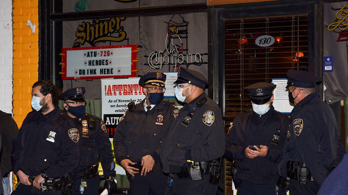 New York City sheriff's deputies stand outside Mac's Public House after co-owner Danny Presti was arrested, Tuesday, Dec. 1, 2020, in the Staten Island borough of New York. (Associated Press)