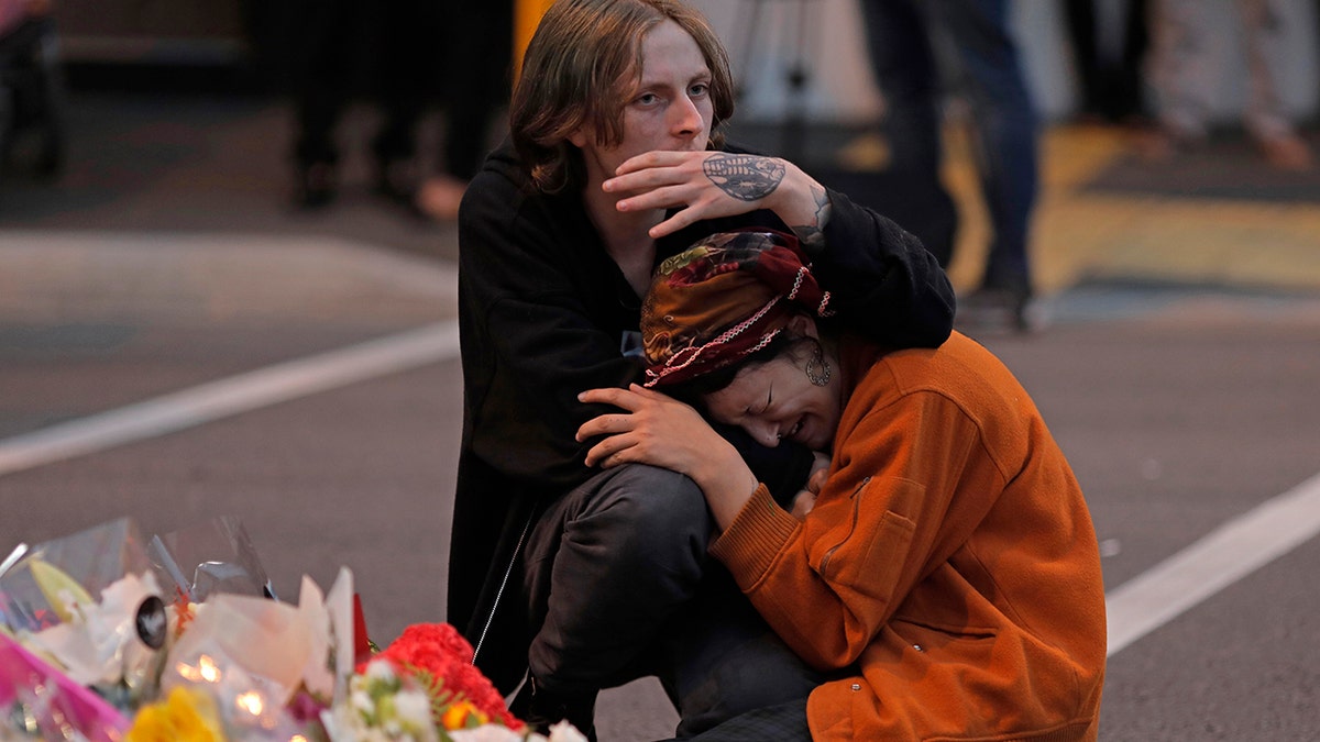 FILE - In this March 16, 2019, file photo, mourners pay their respects at a makeshift memorial near the Masjid Al Noor mosque in Christchurch, New Zealand. A comprehensive report released Tuesday, Dec. 8, 2020 into the 2019 Christchurch mosque shootings in which 51 Muslim worshippers were slaughtered sheds new light on how the gunman was able to elude detection by authorities as he planned out his attack. (AP Photo/Vincent Yu, File)