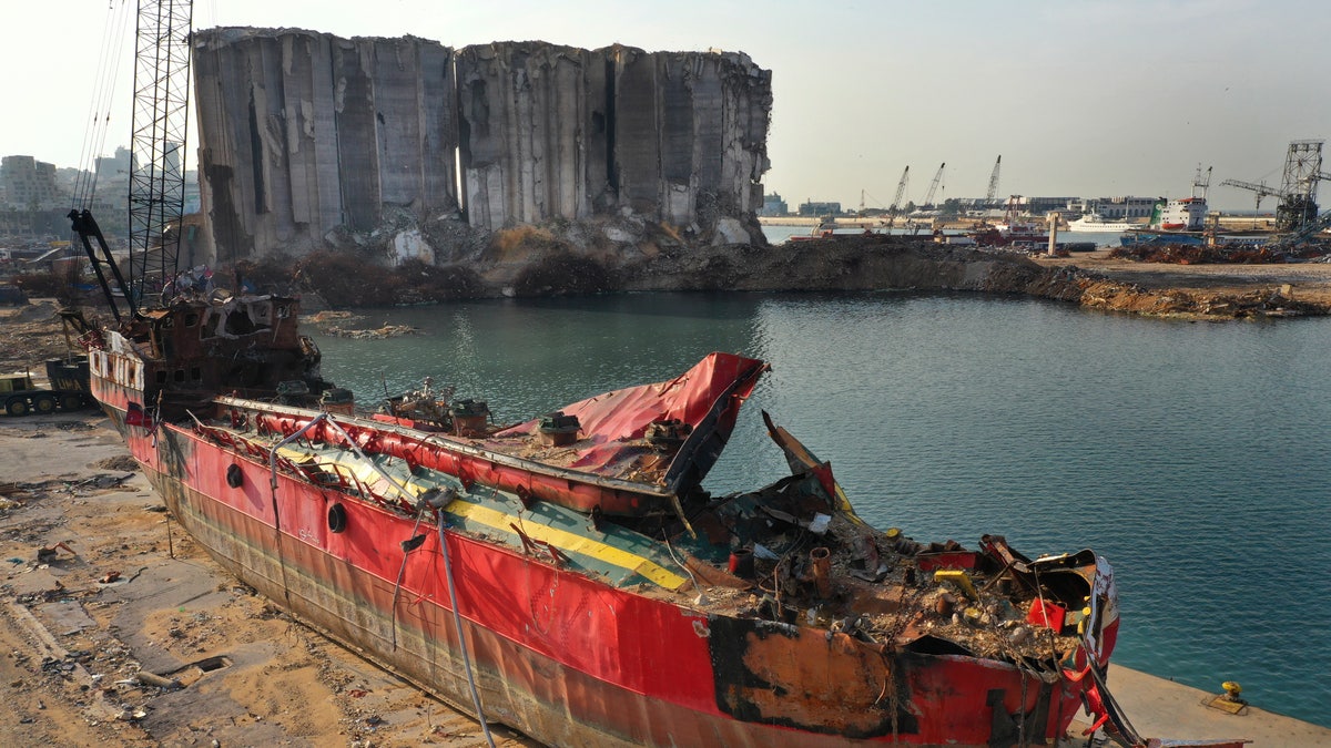 A destroyed ship lies near towering grain silos gutted in the massive August explosion at the Beirut port that claimed the lives of more than 200 people, in Beirut, Lebanon, Wednesday, Dec. 2, 2020. (AP Photo/Hussein Malla)