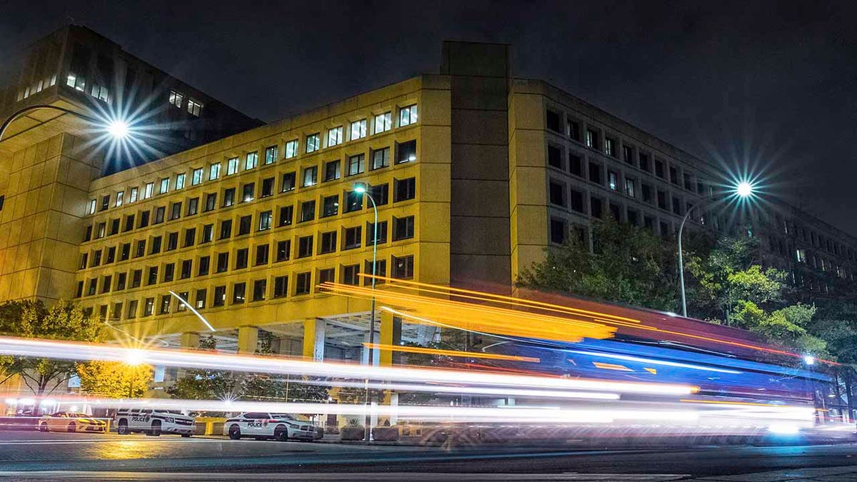 In this Nov. 1, 2017, file photo, traffic along Pennsylvania Avenue in Washington streaks past the Federal Bureau of Investigation headquarters building. (AP Photo/J. David Ake, File)