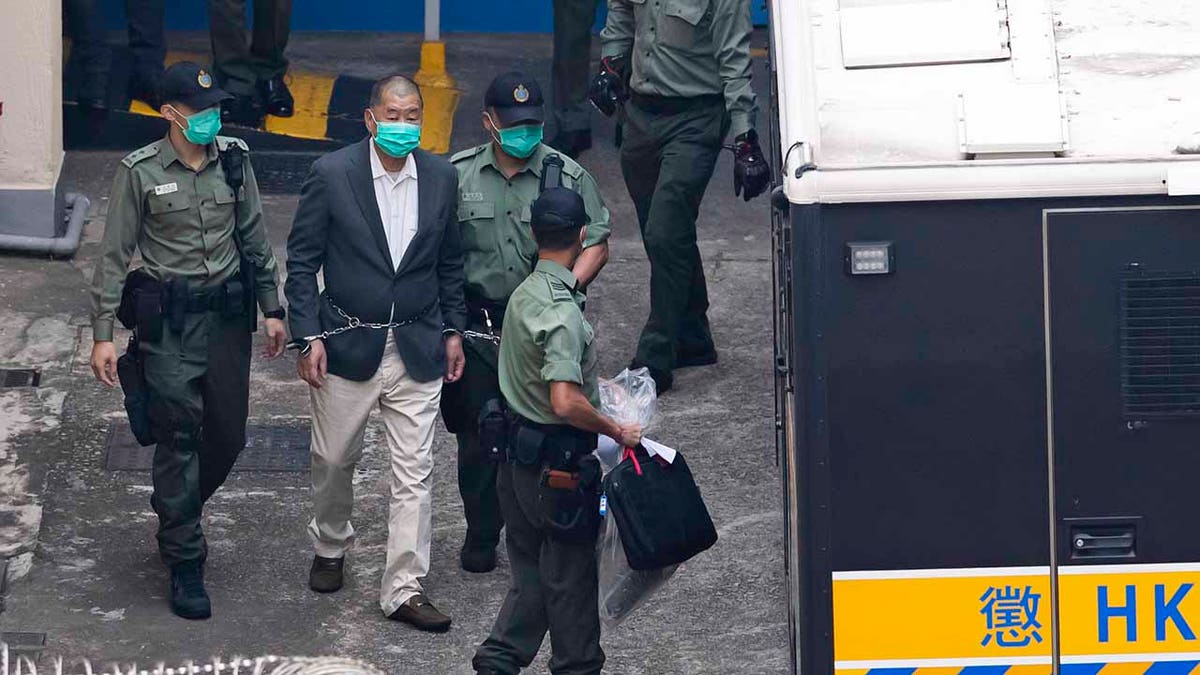 Hong Kong pro-democracy activist and media tycoon Jimmy Lai is escorted by correctional services officers to get on a prison van before appearing in a court, in Hong Kong, Saturday, Dec. 12, 2020. Lai, who founded the Apple Daily tabloid, has been charged under the city’s national security law amid a widening crackdown on dissent, according to local media reports. (AP Photo/Kin Cheung)