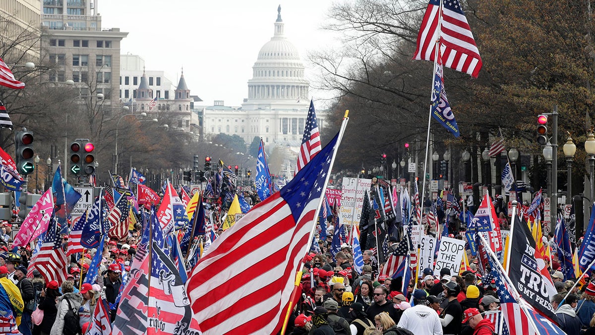 With the U.S. Capitol building in the background, supporters of President Donald Trump stand Pennsylvania Avenue during a rally at Freedom Plaza, Saturday, Dec. 12, 2020, in Washington. (AP Photo/Luis M. Alvarez)
