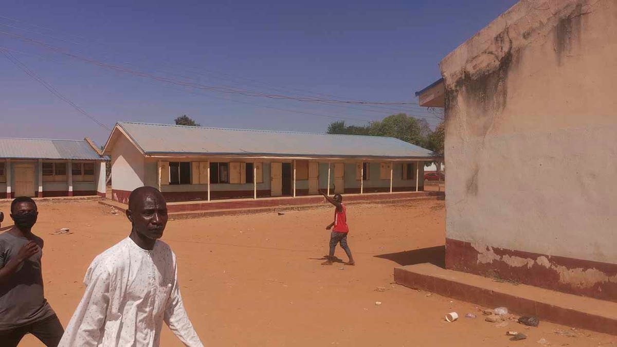 People gather inside the Government Science Secondary School in Kankara, Nigeria, Saturday, Dec. 12, 2020. Nigerian police say that hundreds of students are missing after gunmen attacked the secondary school in the country’s northwestern Katsina state. (AP Photo/Abdullatif Yusuf)