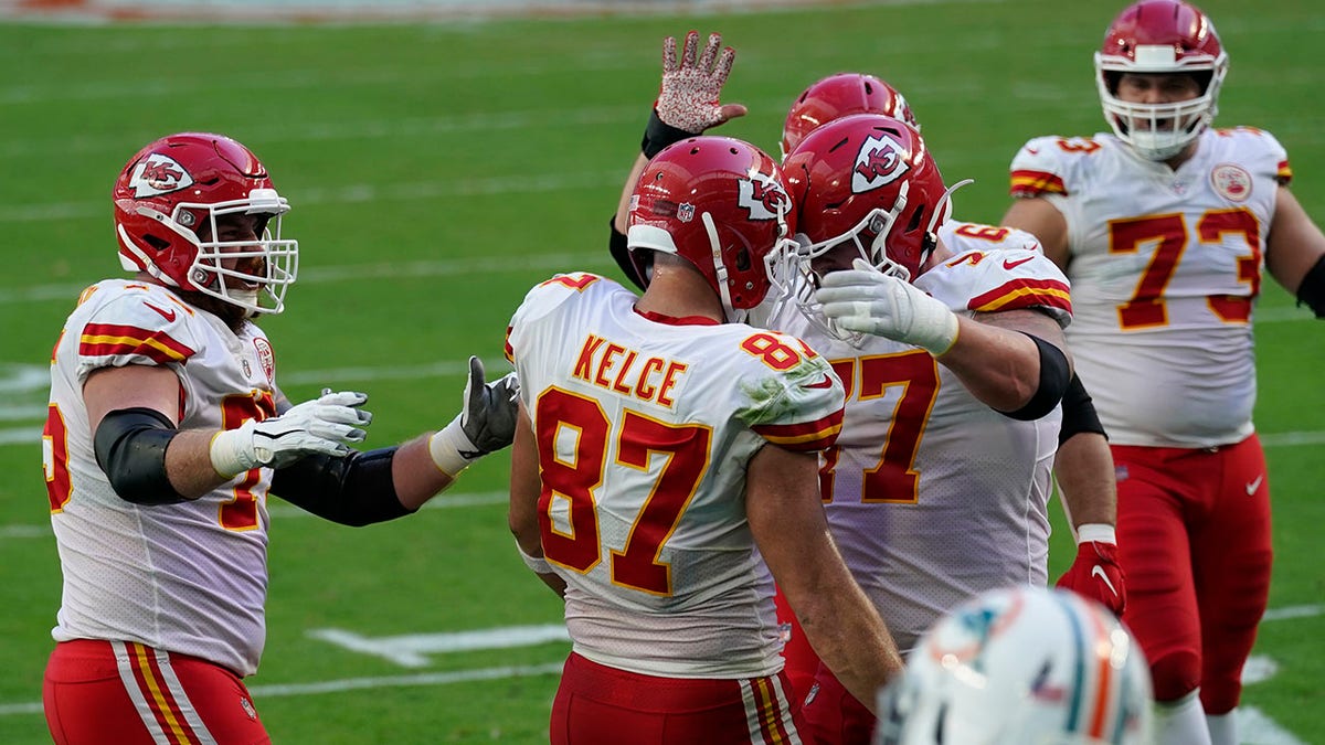 Kansas City Chiefs tight end Travis Kelce (87) is congratulated by his teammates after scoring a touchdown during the first half of an NFL football game against the Miami Dolphins, Sunday, Dec. 13, 2020, in Miami Gardens, Fla. (AP Photo/Lynne Sladky)