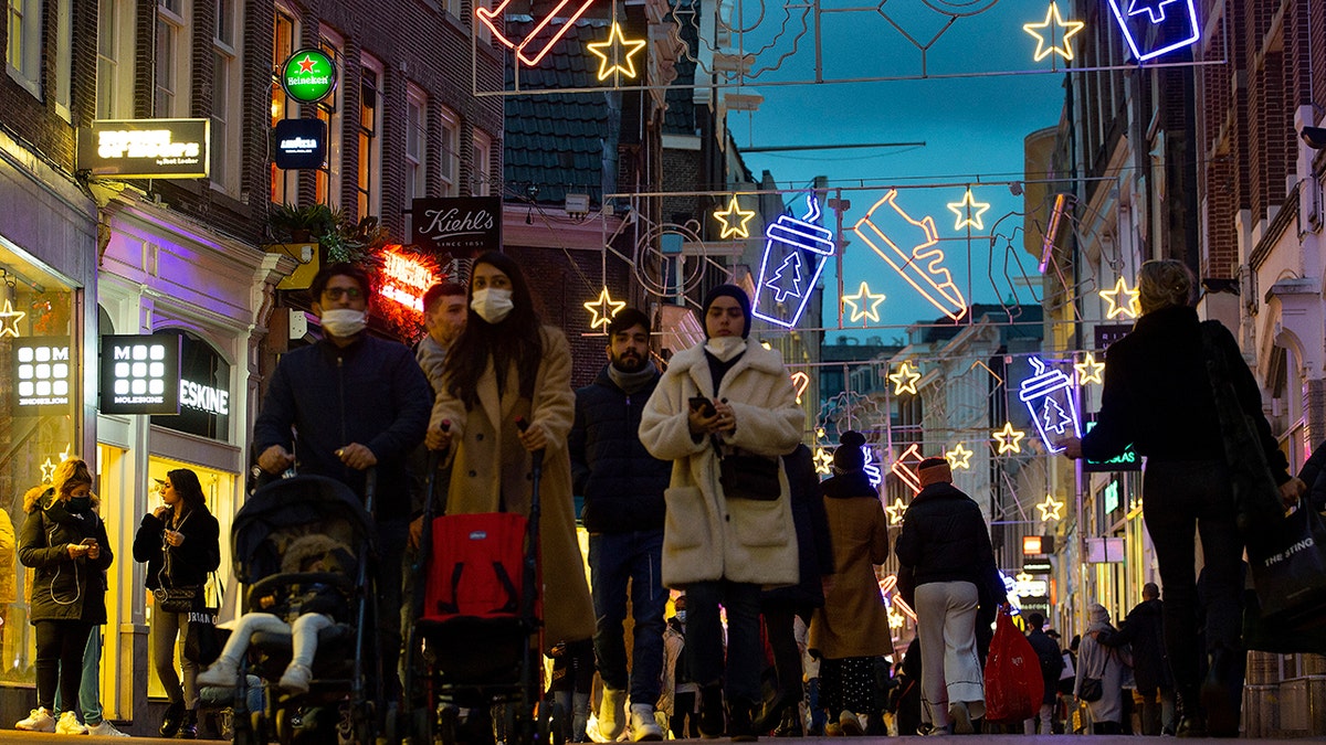 Shoppers walk down Kalverstraat in Amsterdam, Netherlands, Monday, Dec. 14, 2020. (AP Photo/Peter Dejong)