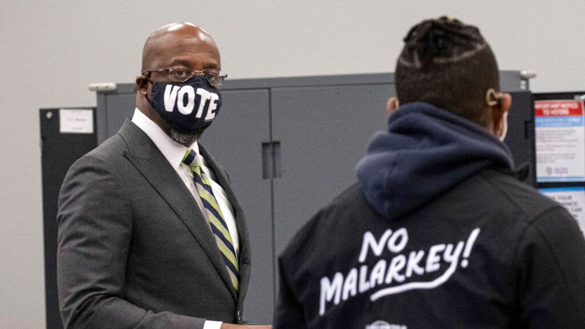 Democrat Georgia Senate challenger Rev. Raphael Warnock arrives to vote at the C.T. Martin Natatorium and Recreation Center in Atlanta on the first day of early voting for the senate runoff Monday, Dec. 14, 2020.
