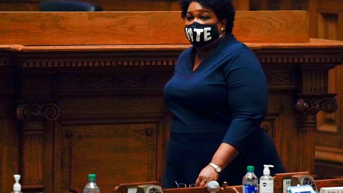 Democrat Stacey Abrams, walks on Senate floor before of members of Georgia's Electoral College cast their votes at the state Capitol, Dec. 14, in Atlanta. (AP Photo/John Bazemore, Pool)