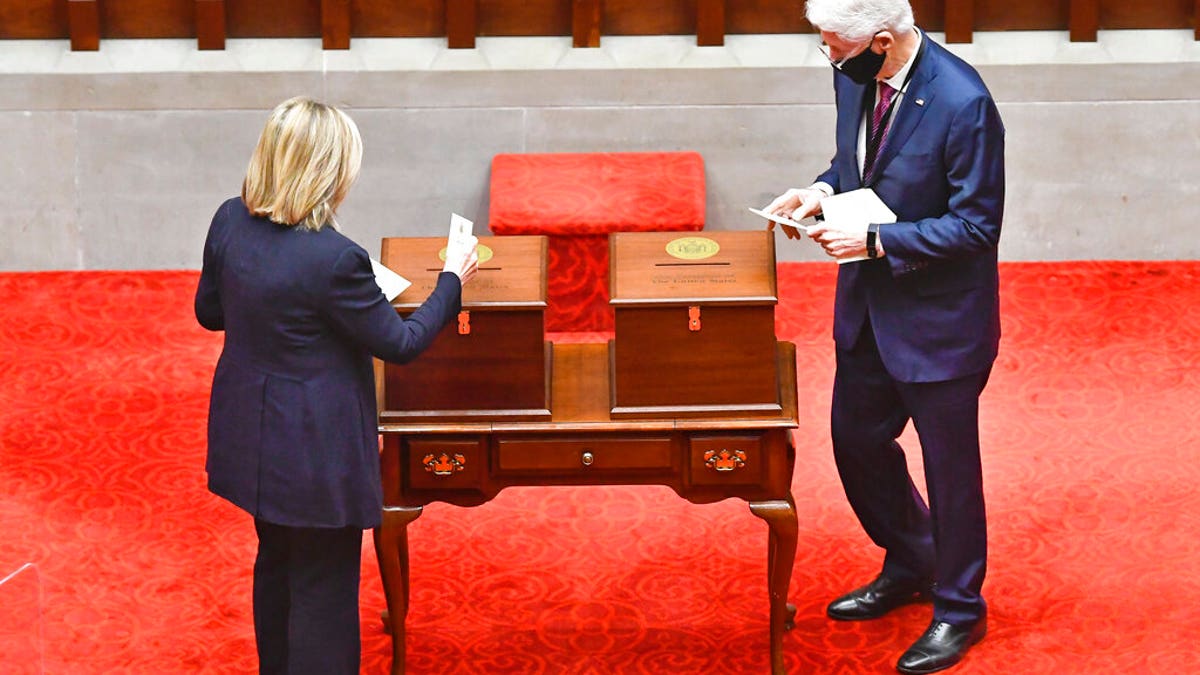 New York Electoral College members, Former Sec. of State Hillary Clinton, left, and Former President Bill Clinton, vote for President and Vice President in the Assembly Chamber at the state Capitol in Albany, N.Y., Monday, Dec. 14, 2020. (AP Photo/Hans Pennink, Pool)