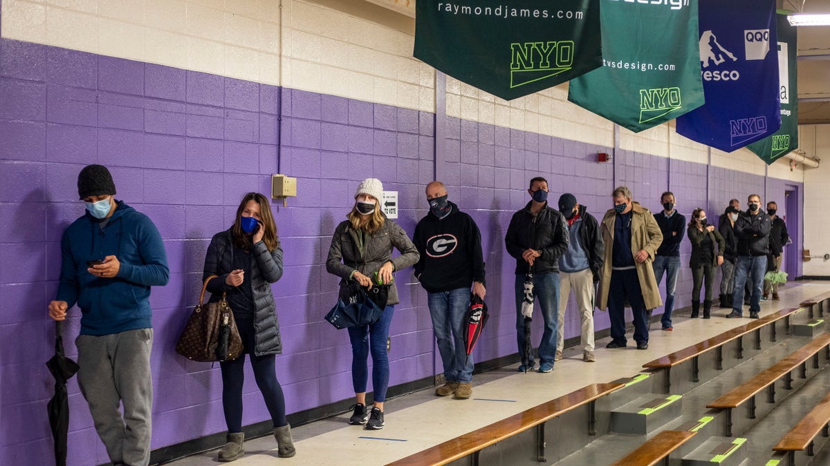 Fulton County voters stand in line to participate in early voting in the state's runoff election at Chastain Park Gymnasium in Atlanta's Chastain Park neighborhood, Dec. 16, 2020. (Alyssa Pointer/Atlanta Journal-Constitution via AP)