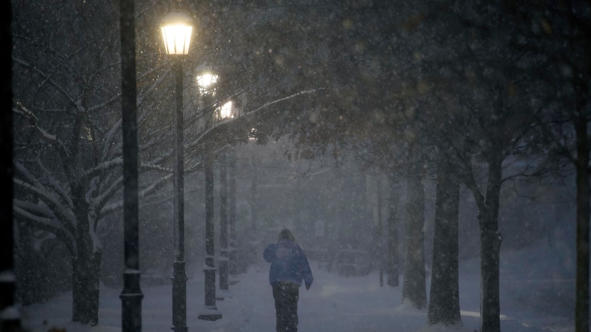 A man walks through the Villanova University campus during a snow storm, Wednesday, Dec. 16, 2020, in Villanova, Pa. (AP Photo/Matt Slocum)