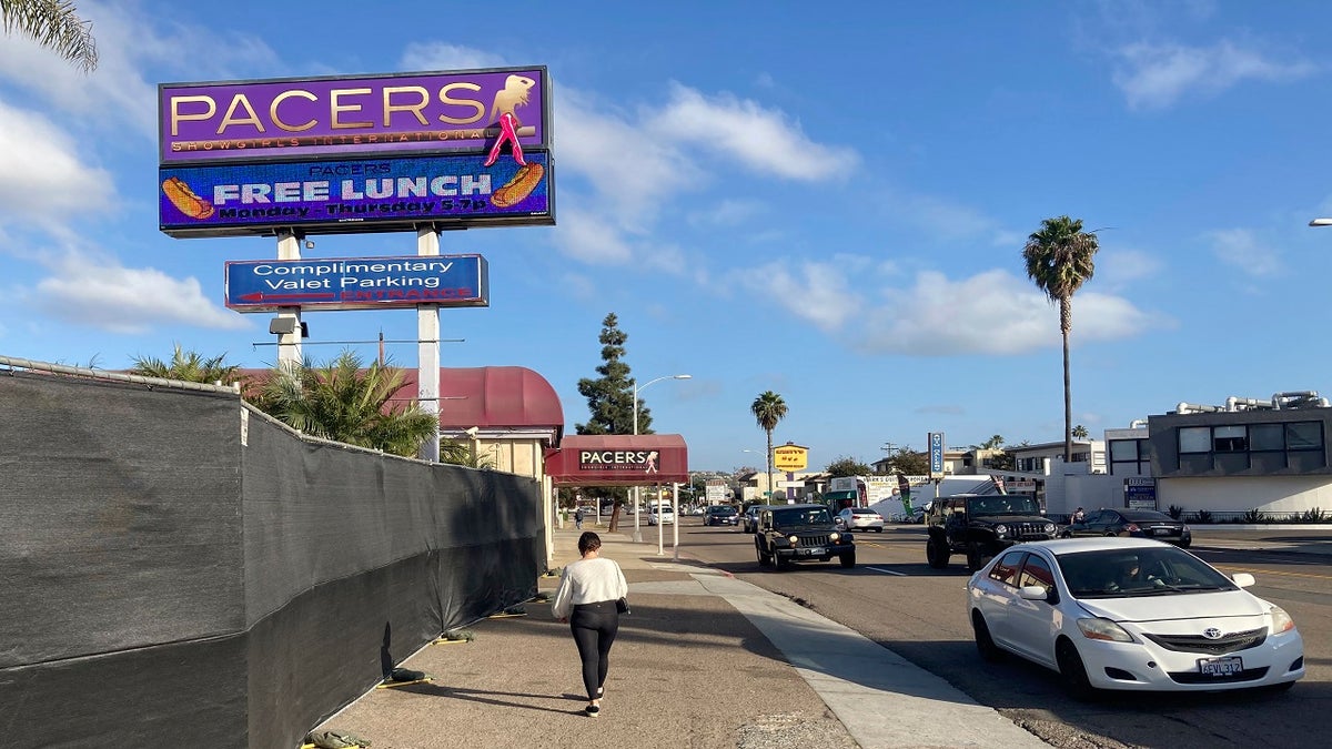 In this Dec. 10, 2020, file photo, a person walks past Pacers Showgirls International in San Diego. (AP Photo/Elliot Spagat, File)