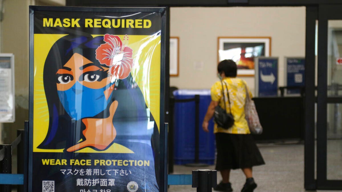 A woman walks into the international airport in Honolulu amid a quarantine rule that effectively shut down the tourism industry in the state. 