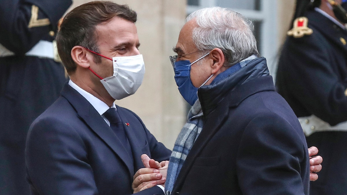 FILE - In this Dec.14, 2020 file photo, France's President Emmanuel Macron, left, welcomes OECD's Secretary General Angel Gurria for a working lunch at the Elysee Palace in Paris. Macron's aides have scrambled to contact all the people he had been near in recent days. The French health minister suggested that he might have been infected at an EU summit in Brussels last week, but Macron had multiple meetings in Paris as well. Emmanuel Macron's positive test comes as French health authorities are again seeing a rise in infections and warning of more as French families prepare to get together for Christmas and New Year festivities. (AP Photo/Michel Euler, File)