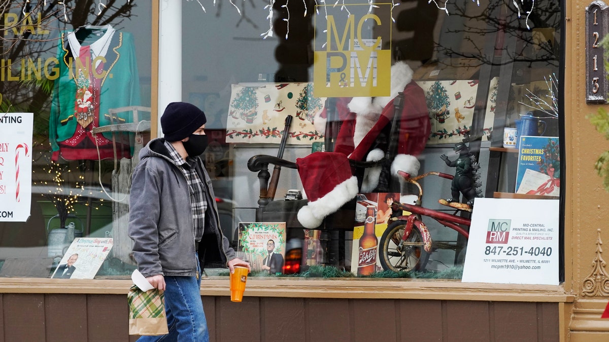 Christmas cards and costumes are displayed in the window at Mid Central Printing &amp; Mailing store in Wilmette, Ill., Friday, Dec. 18, 2020. (AP Photo/Nam Y. Huh)