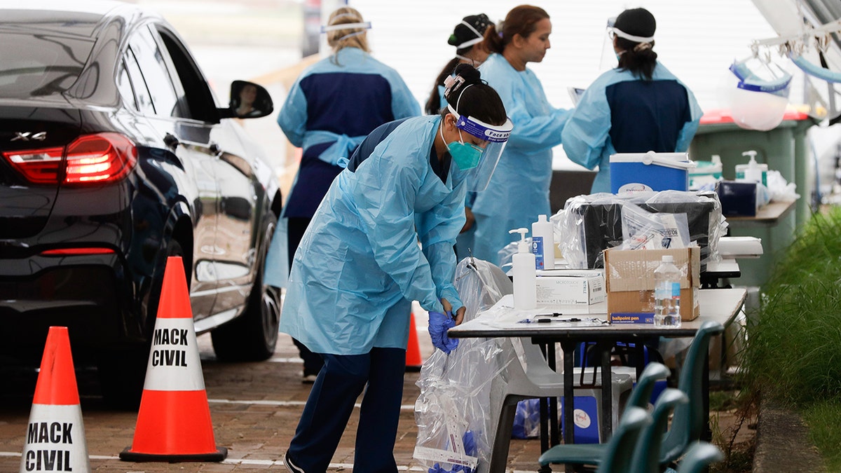 Staff prepare to test people at a drive through COVID-19 testing station at a beach in Sydney, Australia, Saturday, Dec. 19, 2020. Sydney's northern beaches will enter a lockdown similar to the one imposed during the start of the COVID-19 pandemic in March as a cluster of cases in the area increased to more than 40. (AP Photo/Mark Baker)