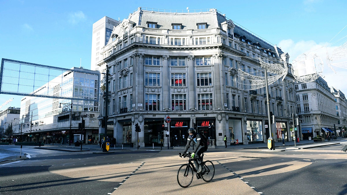 A cyclist passes Oxford Circus after Britian's Prime Minister Boris Johnson introduced Tier 4 restrictions for London and the southeast of the country, in London, Sunday, Dec. 20, 2020. Millions of people in England have learned they must cancel their Christmas get-togethers and holiday shopping trips. (Stefan Rousseau/PA via AP)