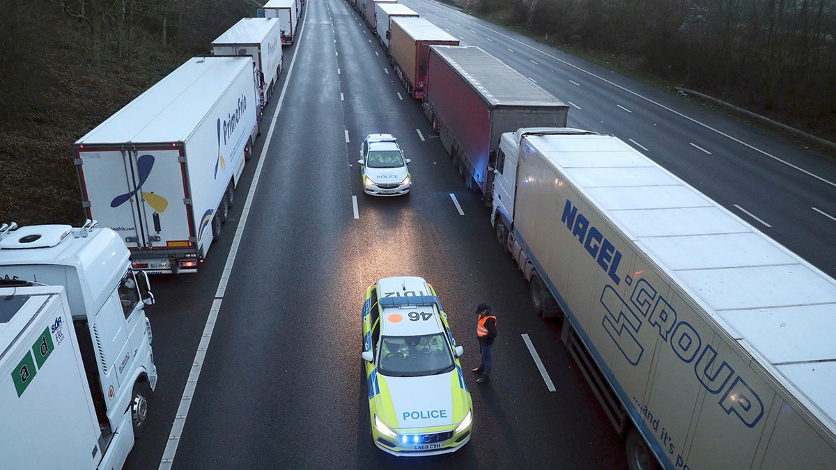 Police patrol along the M20 motorway where freight traffic is halted whilst the Port of Dover remains closed, in Ashford, Kent, England, Tuesday, Dec. 22, 2020. (Andrew Matthews/PA via AP)
