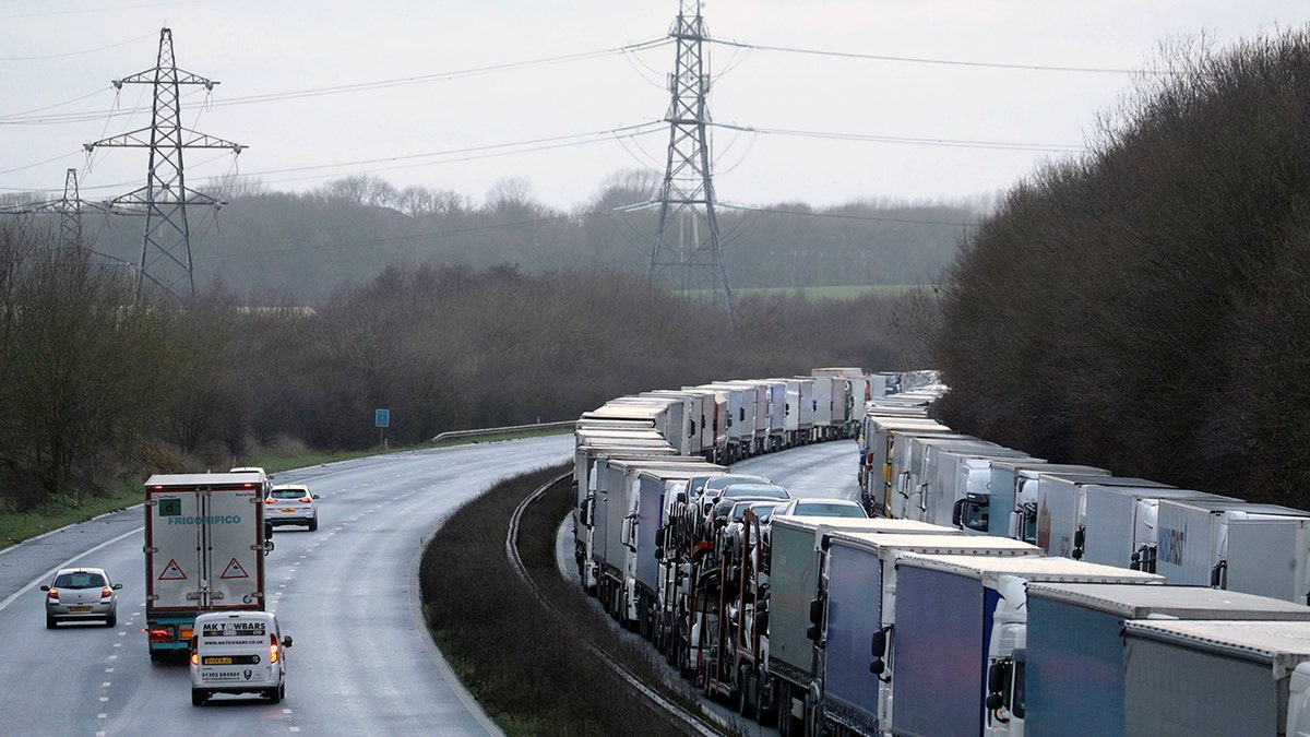 Trucks are parked along the M20 motorway where freight traffic is halted whilst the Port of Dover remains closed, in Ashford, Kent, England, Tuesday, Dec. 22, 2020.  (Andrew Matthews/PA via AP)