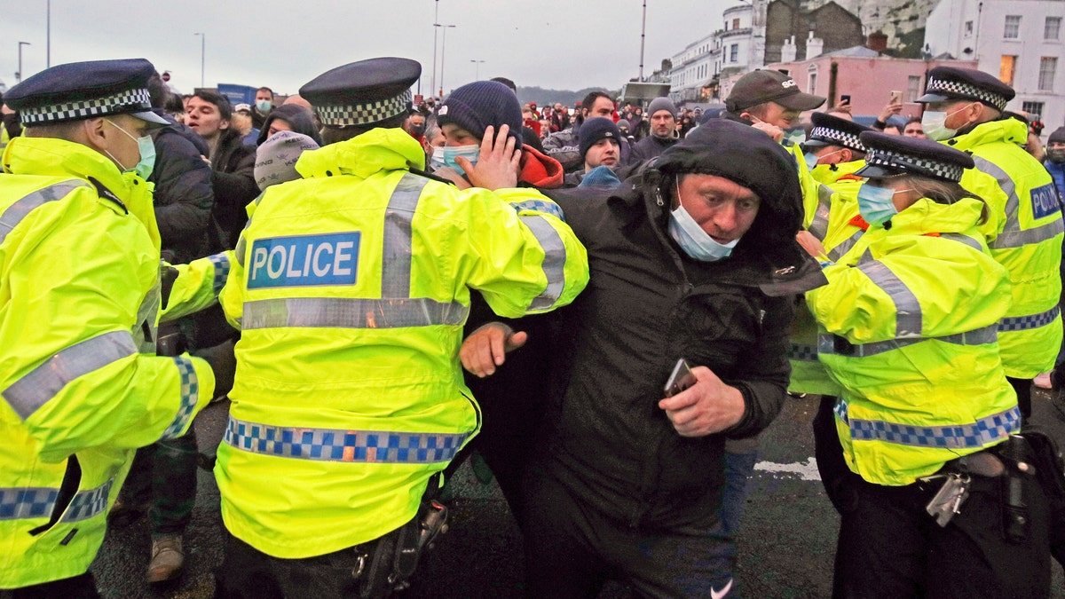 Truck drivers argue with police holding them back at the entrance to the Port of Dover, in Kent, England, Wednesday Dec. 23, 2020.  (Steve Parsons/PA via AP)