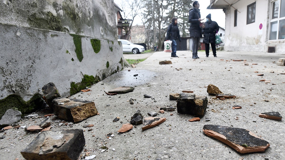 Residents inspect damage caused by an earthquake in Sisak, Croatia, Monday, Dec. 28, 2020. A moderate earthquake has hit central Croatia near its capital of Zagreb, triggering panic and some damage south of the city. There were no immediate reports of injuries. (AP Photo)