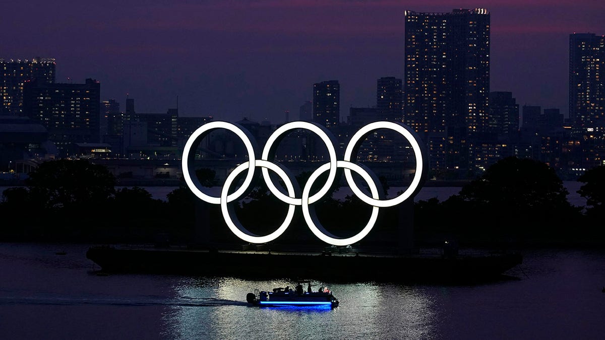 FILE - In this June 3, 2020, photo, the Olympic rings float in the water at sunset in the Odaiba section in Tokyo. The year of the Tokyo 2020 Olympics has arrived. (AP Photo/Eugene Hoshiko, File)